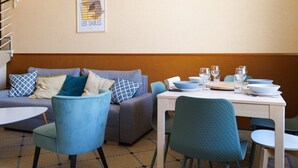 Een eetgedeelte met een bank, stoelen en een tafel gedekt voor een maaltijd.