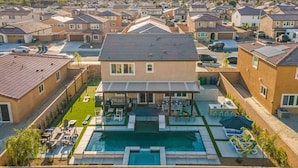 A residential area with houses, a swimming pool, and a covered patio area. - Entertainer`s Paradise | Luxe Pool + Game Room (Coachella)