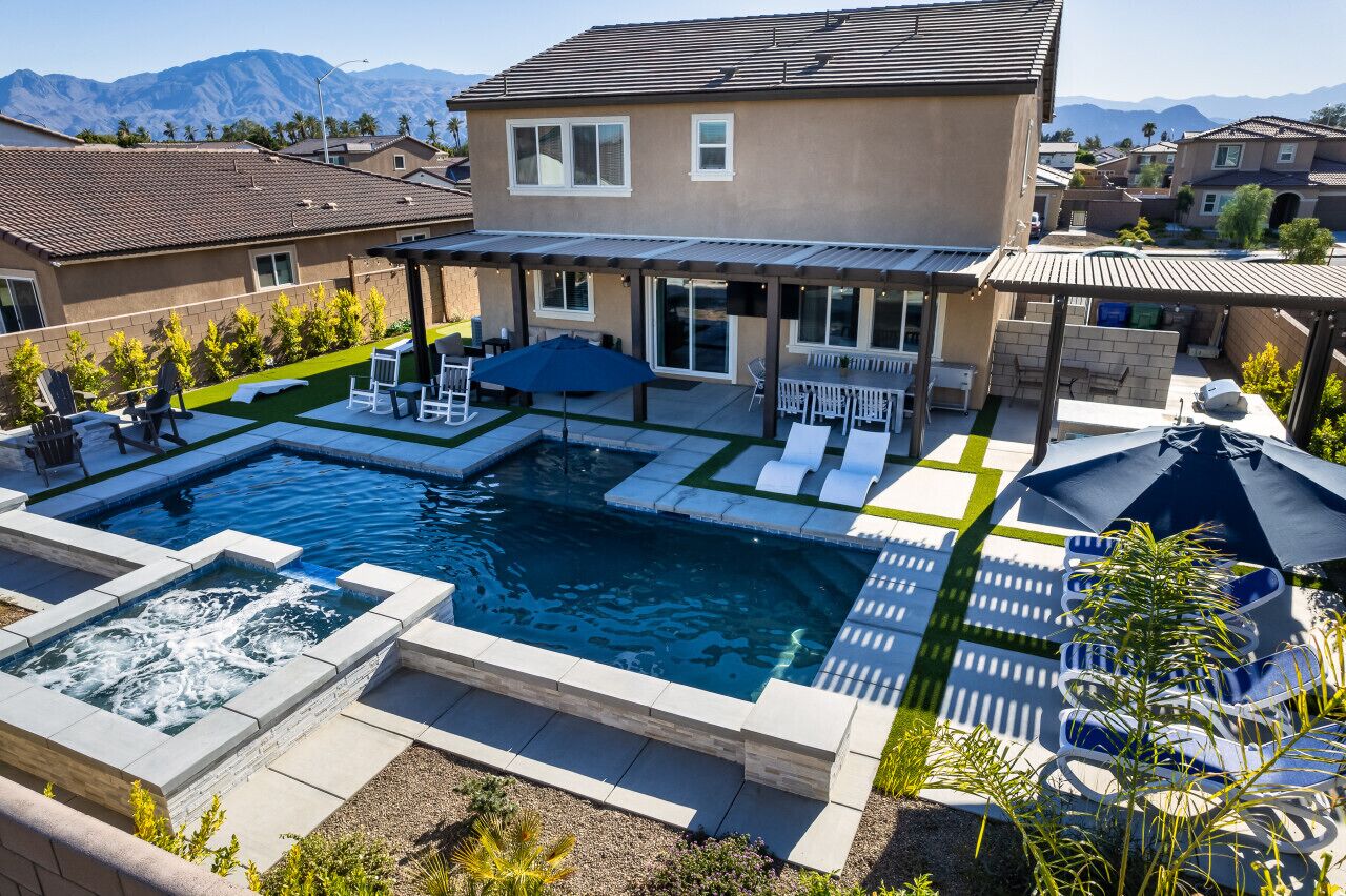 Um imóvel residencial com piscina, área de pátio com mobiliário externo e vista para montanhas.