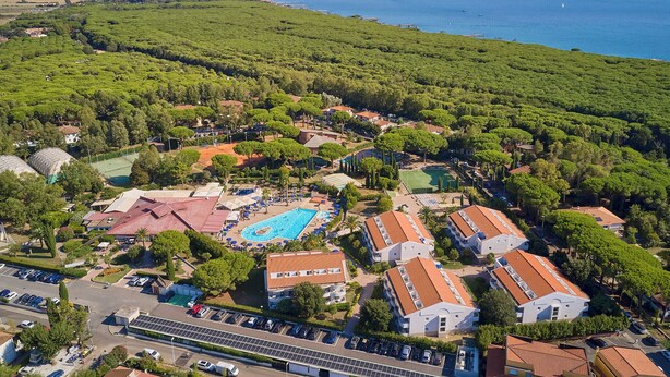An aerial view of a resort with a swimming pool, villas, and a view of the sea. - Hotel La Buca Del Gatto (Cecina)