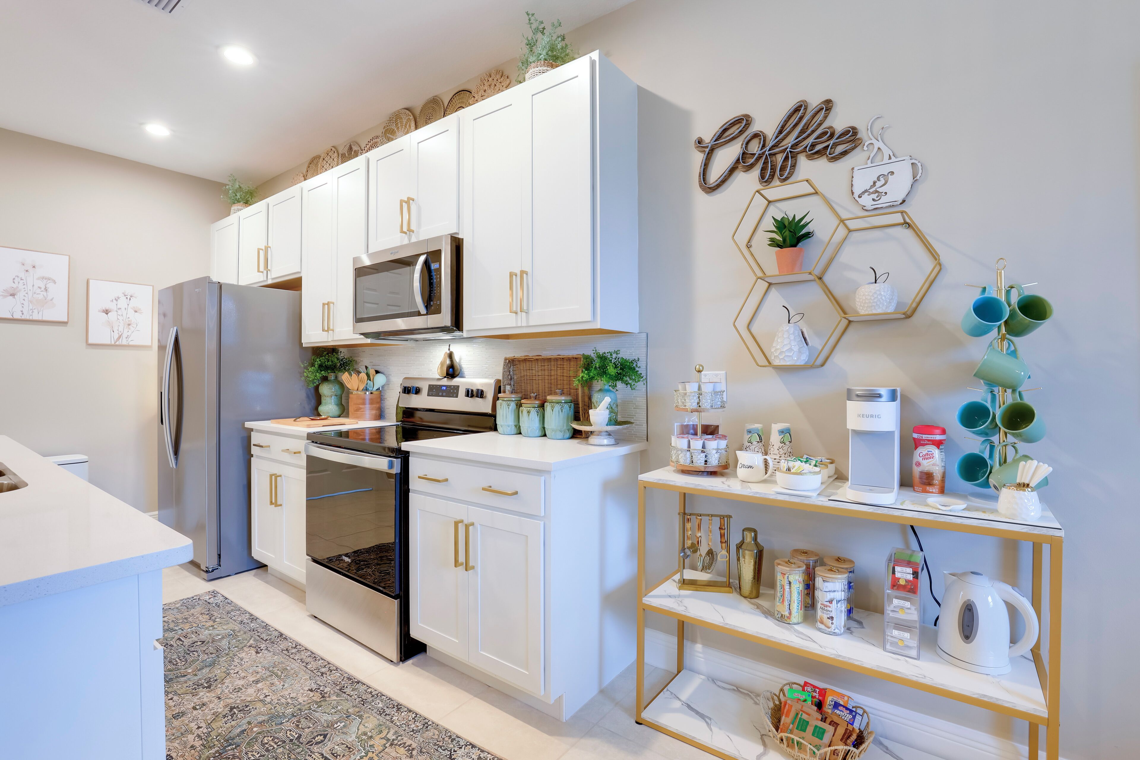 Una cocina moderna con muebles blancos, electrodomésticos de acero inoxidable y decoración con motivos de café.