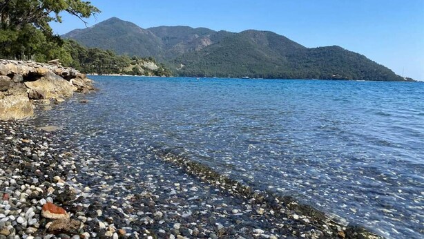 A clear lake with rocky shore, surrounded by mountains. - Club Bellamare Beach (Marmaris)