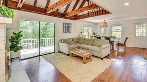 A spacious living area with a wooden ceiling, a large sofa, a coffee table, and a dining area with a table and chairs. - Waterfront Gainesville Home w/ Private Boat Dock! (Gainesville)