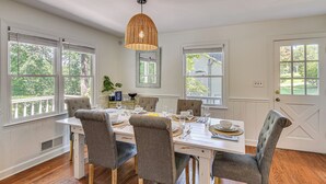 A dining area with a white table set for four, surrounded by upholstered chairs, under a woven pendant light. - Waterfront Gainesville Home w/ Private Boat Dock! (Gainesville)
