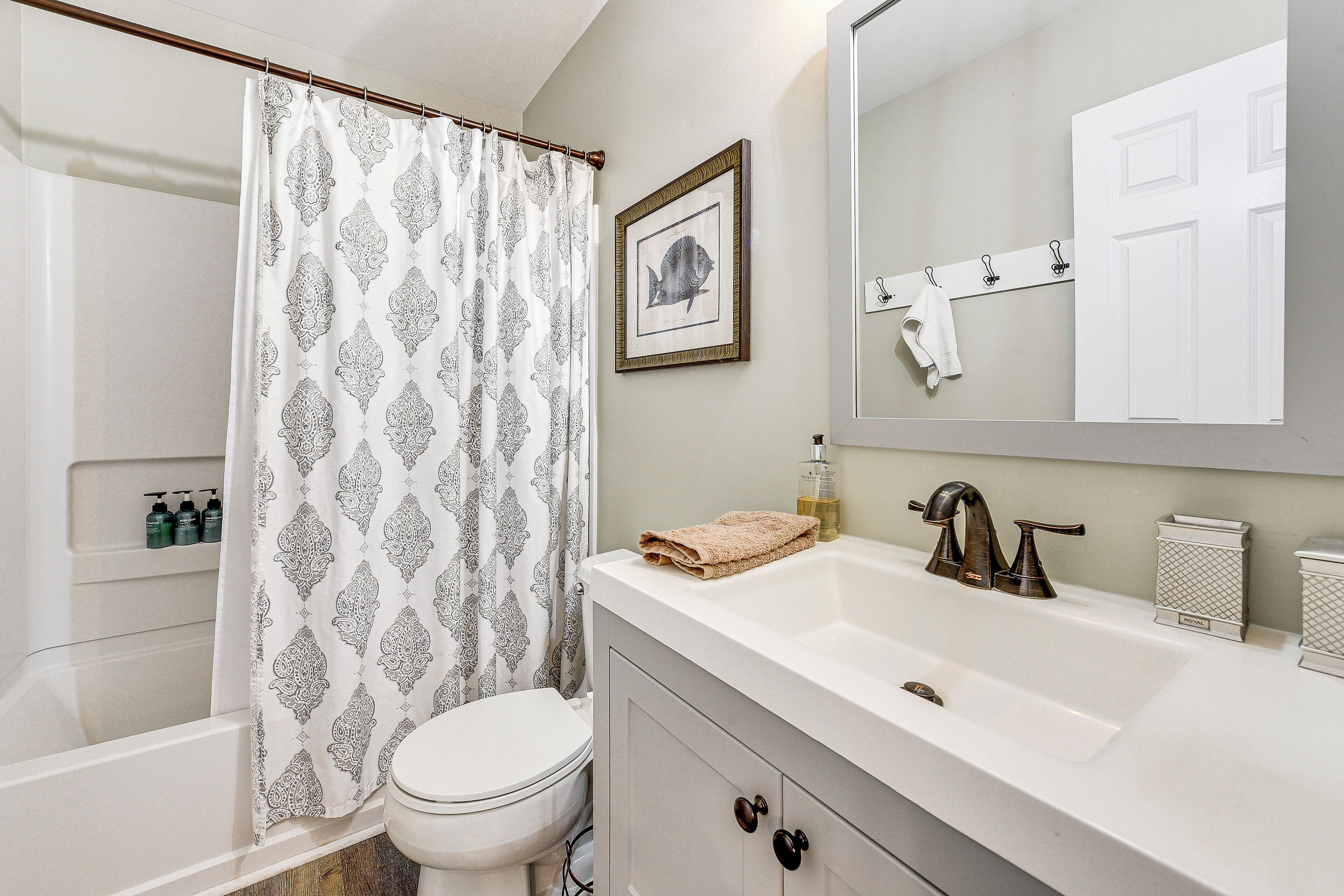 A bathroom with a bathtub, toilet, and sink.
