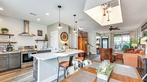 A spacious kitchen with a central island, stainless steel appliances, and pendant lighting.