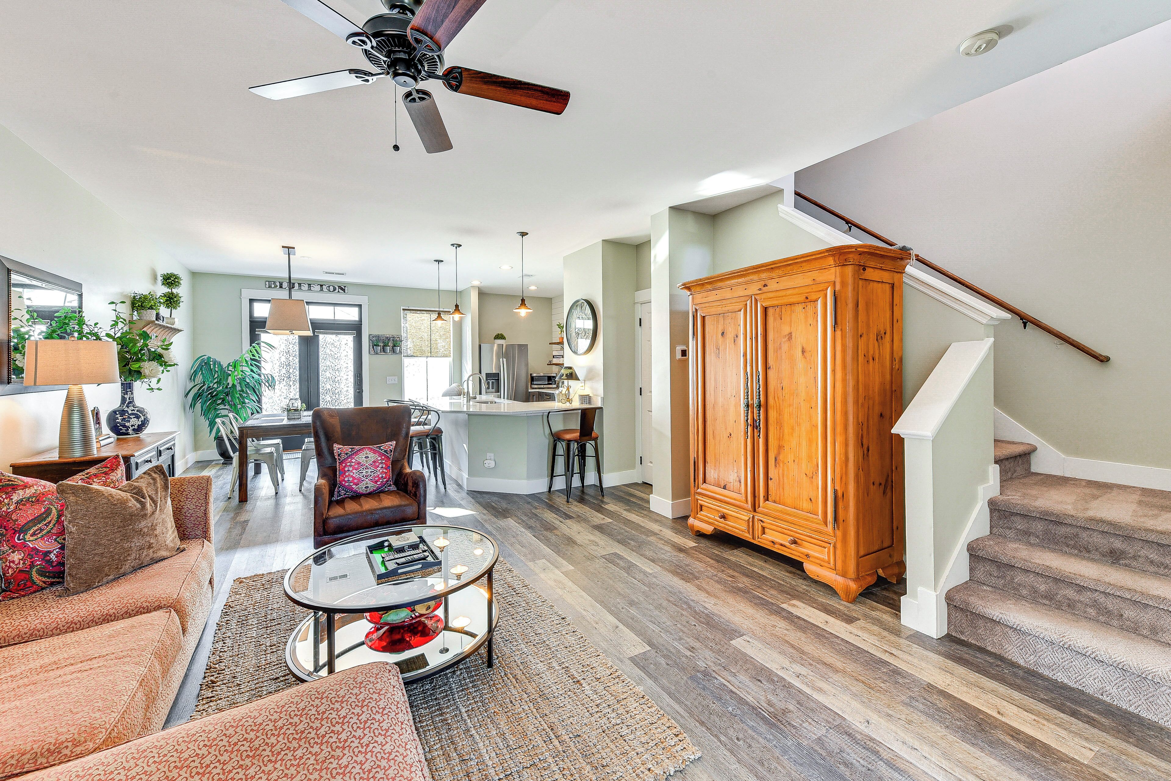 A spacious living room with a sofa, coffee table, and a wooden cabinet.