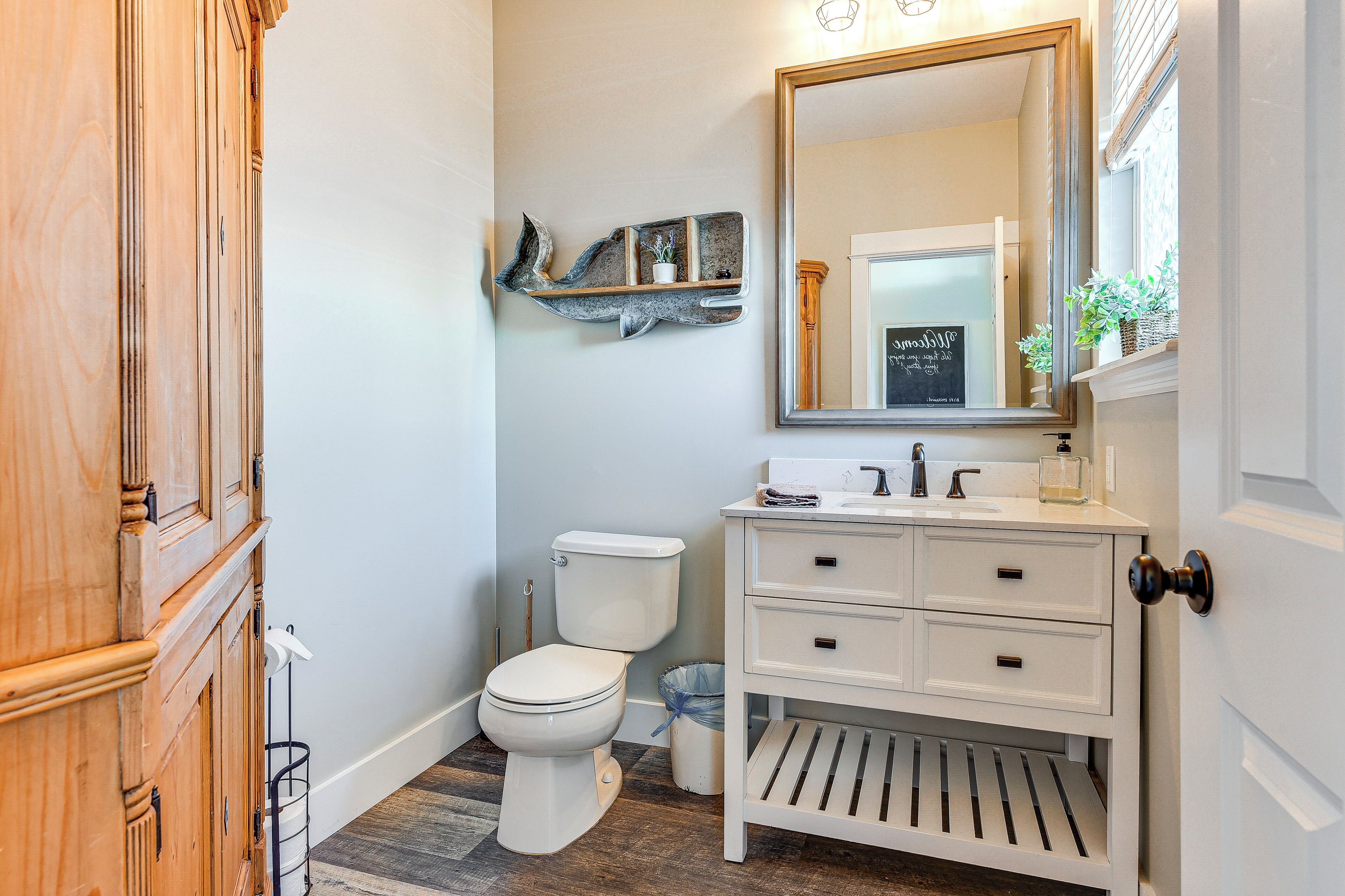 A bathroom with a toilet, a sink, and a mirror.