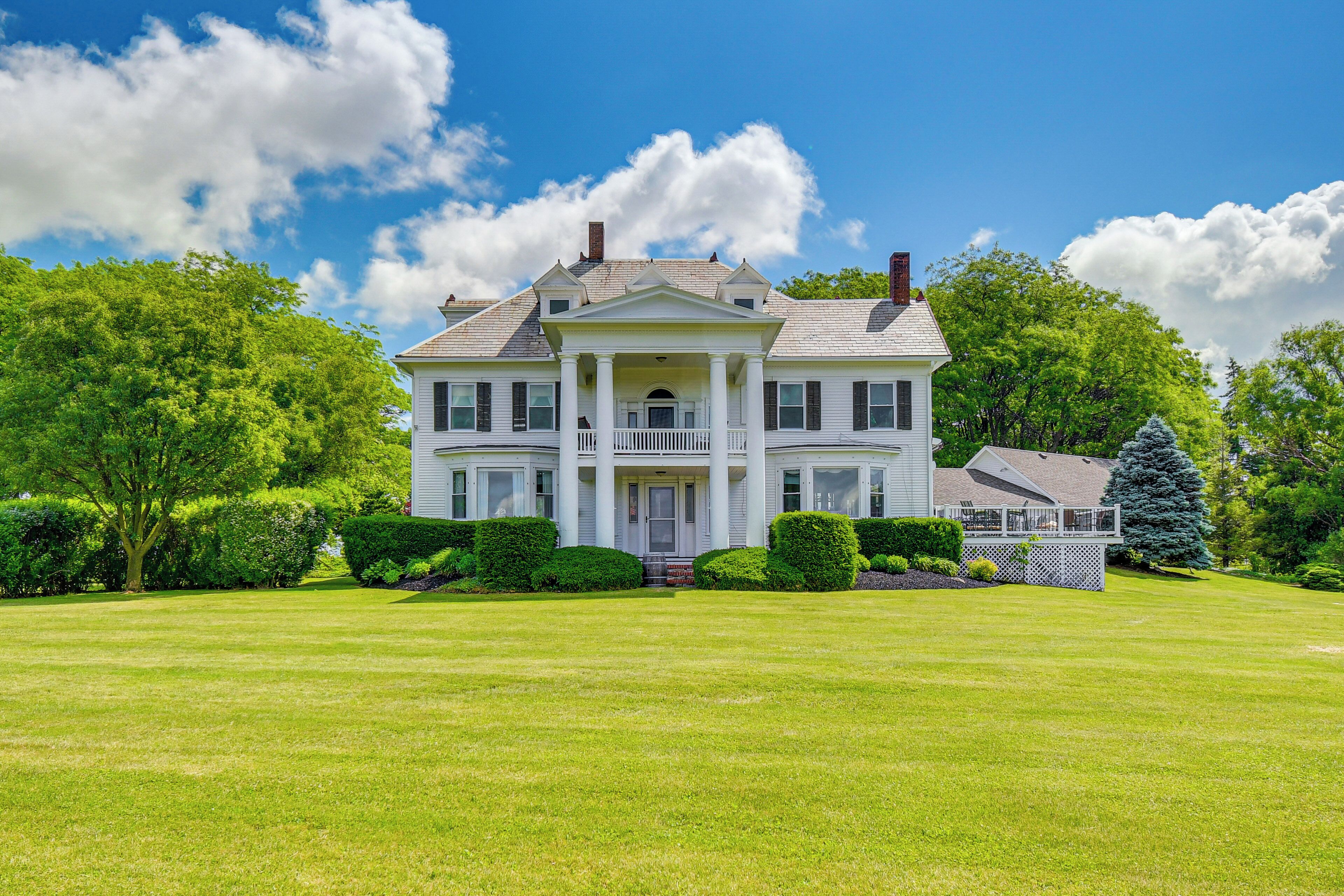 A large, two-story house with a front porch and a well-maintained lawn.