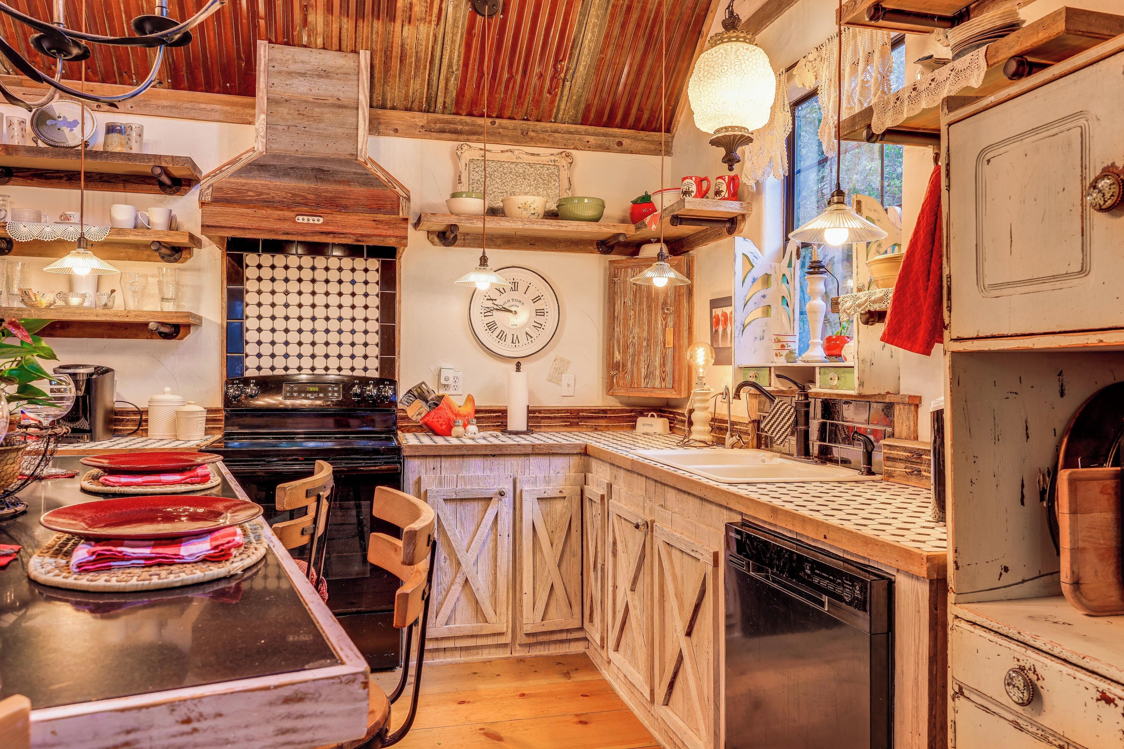 A rustic kitchen with wooden cabinets, a large stove, and a dining area with a table set for a meal.