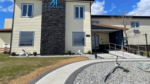 Un hotel moderno con fachada de piedra y cielo azul despejado.
