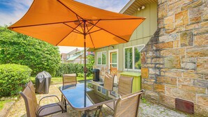 An outdoor patio with a glass table and chairs, an orange umbrella, and a stone wall. - 15 Mi to Seven Springs Resort: Somerset Home! (Somerset)
