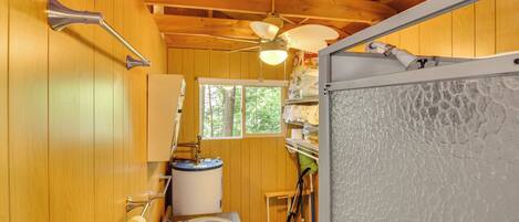 Une petite salle de bain en bois, comprenant des toilettes, un lavabo et une douche.