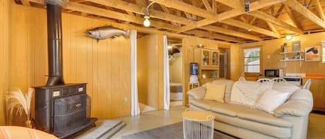 Un intérieur de chalet chaleureux avec un poêle à bois, un canapé et un coin repas.