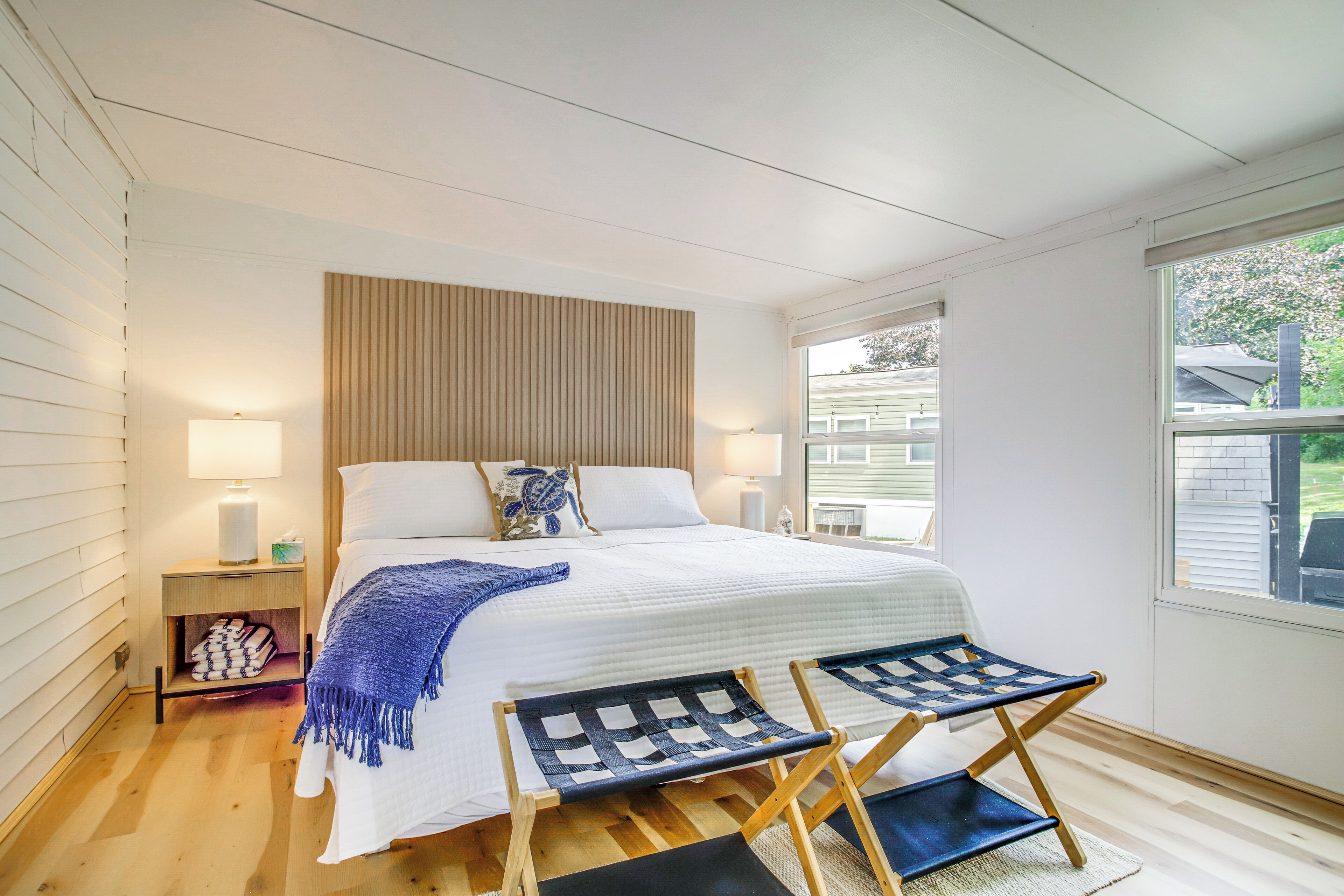 Een slaapkamer met een groot bed, nachtkastjes, een raam en uitzicht op de omgeving.