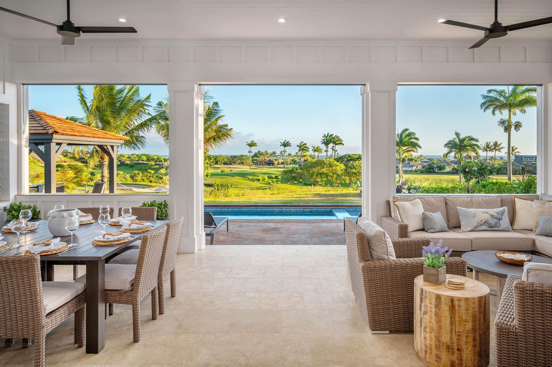 A spacious room with a dining area, a sofa, and a view of a golf course and pool.