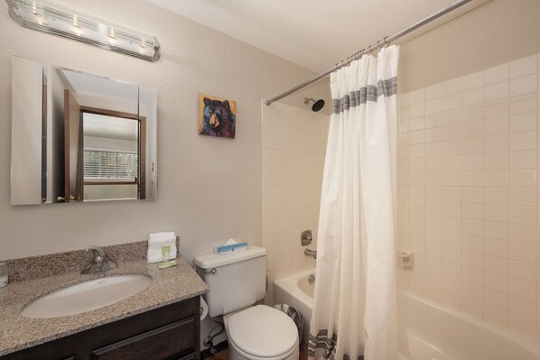 Un baño con lavamanos, inodoro y bañera.