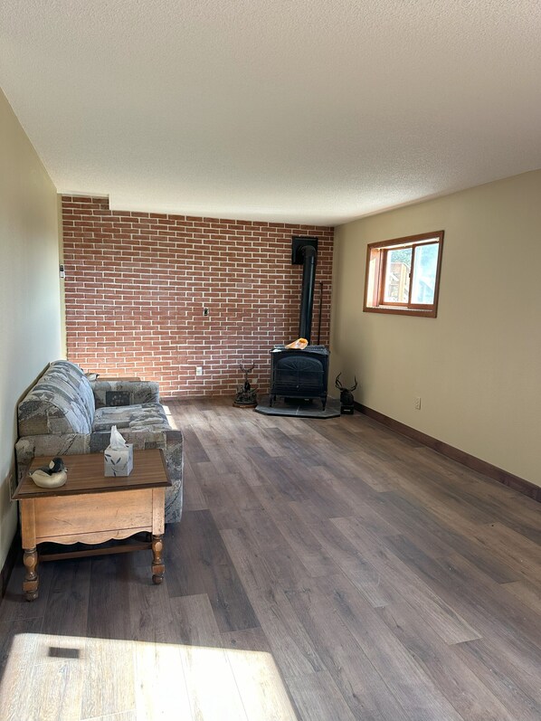 A living room with a brick wall, a fireplace, a sofa, and a wooden coffee table.