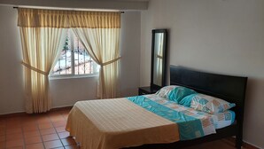 A bedroom with a bed, curtains, a nightstand, and a mirror. - Enjoy the historical center of Cali  (Cali)