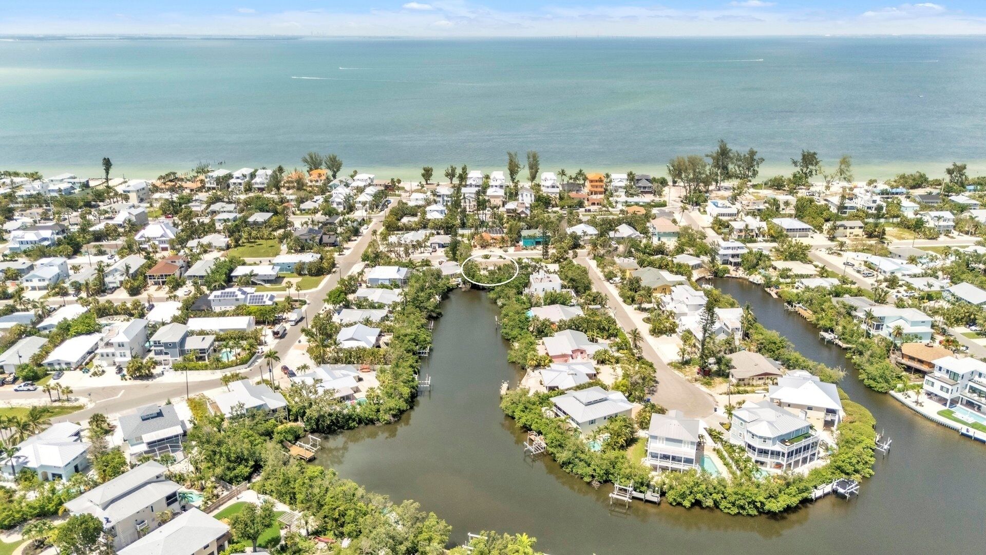 Zona residencial costeira com casas, um rio e vista para o oceano.