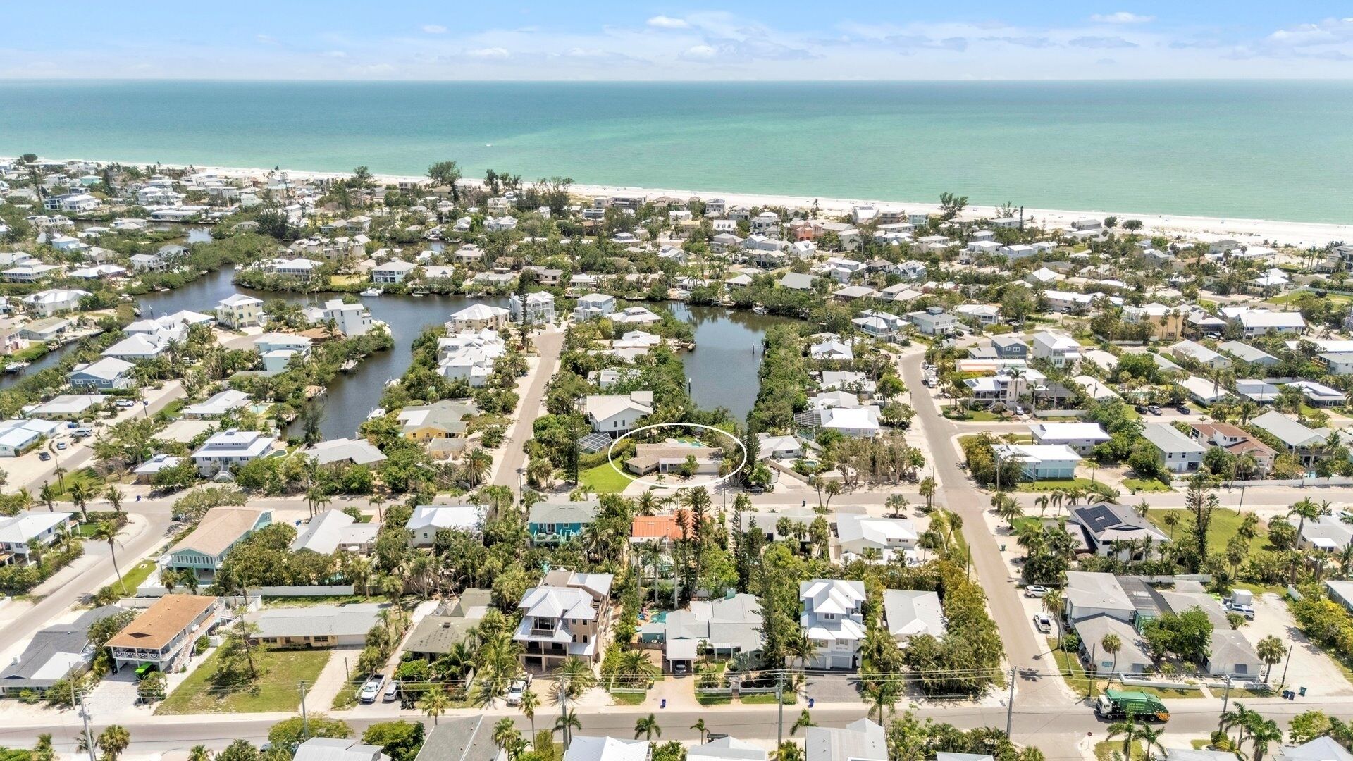 A coastal residential area with houses, a beach, and a marina.