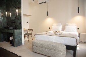 A modern bedroom with a bed, bedside tables, a chair, and a bench. - Mouchki (Marseille)