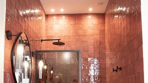 A modern bathroom with a large mirror, a black sink, and a glass-enclosed shower. - Mouchki (Marseille)