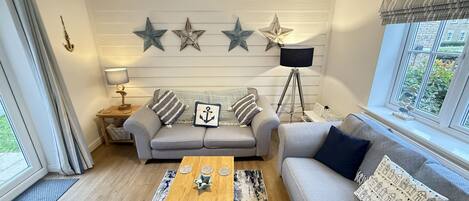 A living room with a grey sofa, a wooden coffee table, and a lamp.
