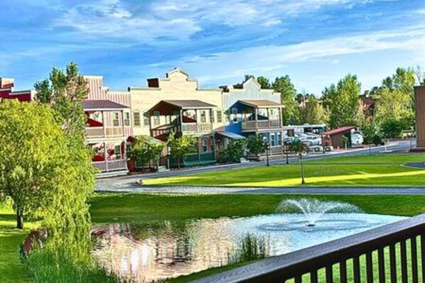 A residential street with houses, a fountain, and a clear sky.