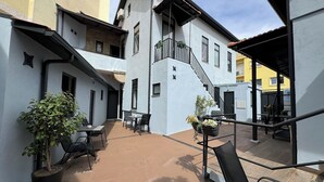 Un patio con mobiliario exterior, una escalera y plantas en macetas.
