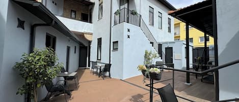 A courtyard with outdoor seating, a staircase, and potted plants.