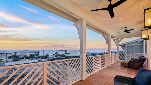 A covered balcony with a view of the ocean, white railings, and ceiling fans. - Relax in Style Steps to the Beach • Heated Pool, Gulf Views, & Room for Everyone (Inlet Beach)