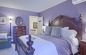 A bedroom with a large bed, a dresser, a chair, and a mirror. - North Lodge Bed & Breakfast (Asheville)