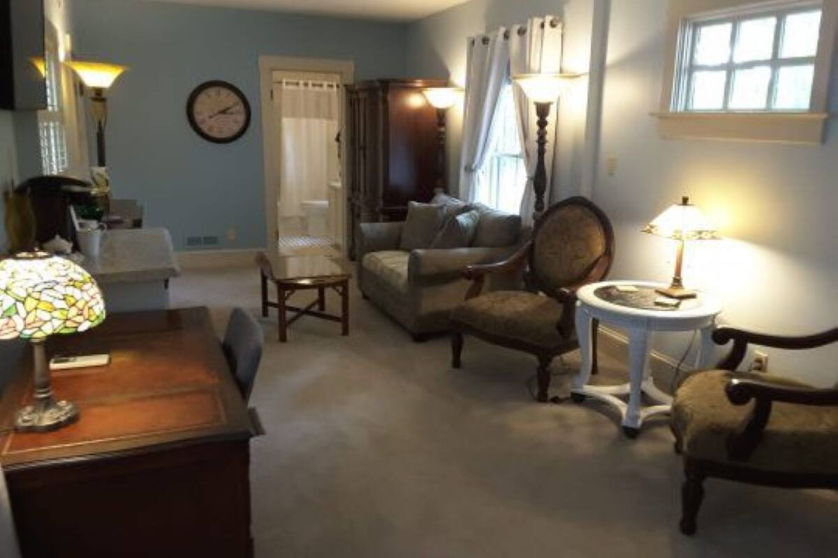 Een gezellige woonkamer met een bank, fauteuils, een salontafel en een eettafel.