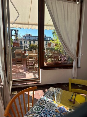 A terrace with outdoor seating, a view of the city, and a window with a curtain. - The Up Hotel is located 300 meters from Naples Central Station. (Napoli)