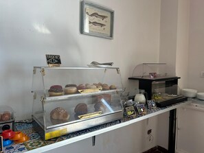 Une vitrine de boulangerie présentant diverses pâtisseries et un panneau indiquant « BRIOCHES ».