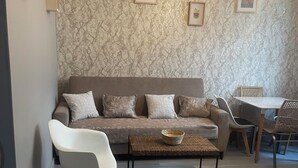 Ein Wohnzimmer mit einer Couch, einem Couchtisch und einem Essbereich mit Stühlen und einem Tisch.