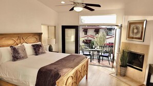 A bedroom with a large bed, a ceiling fan, a fireplace, and a balcony with outdoor seating. - Beauty by the Beach Socal Fun! (Long Beach)