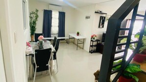 Een modern appartement met een eethoek, een trap en kamerplanten.