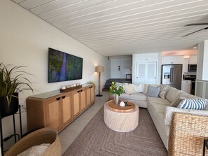 Ein modernes Wohnzimmer mit einem Holzkasten, einem runden Couchtisch, einer Couch und einem Bild an der Wand.