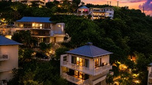 Zona residencial con casas de varios pisos, algunas con balcones, rodeada de vegetación.