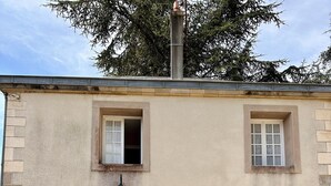 A two-story building with a white door, two windows, and a small balcony.
