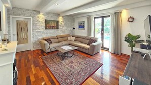 Un salon spacieux avec un grand canapé d’angle, une table basse et un tapis à motifs.