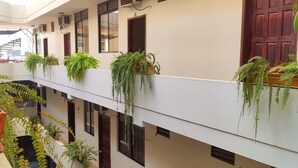 Un edificio a più livelli con balconi decorati con piante in vaso.