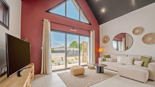 A modern living room with a large TV, a sofa, and a coffee table. - Maison Simone - Belle Maison pour 6 (Lesneven)