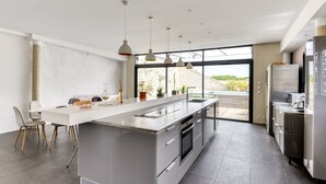 A modern kitchen with a large island, stainless steel appliances, and pendant lighting. - Le Couvent des Ursulines - Appt climatisé, piscine (Narbonne)