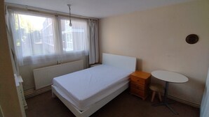 A bedroom with a single bed, a bedside table, a chair, and a small round table. - Lovely Double Bedroom - Putney (London)