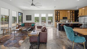 A modern kitchen with wooden cabinets, a stainless steel refrigerator, and a bar area. - The Reserve at Kirby Landing (Kirby)