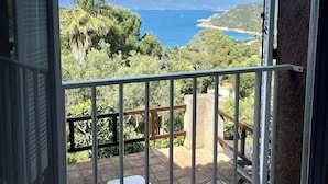 A balcony with a view of a mountainous landscape and a body of water. - Villa Gardelina (Corsica)
