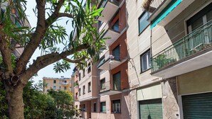 A multi-story residential building with balconies, a tree in the foreground, and a clear sky. - Santa Margherita Apartment in the city (Santa Margherita Ligure)